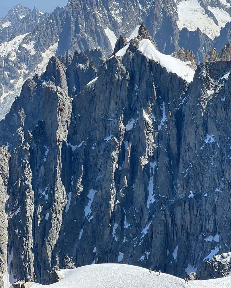 Cordées sur l'arête de neige sous les aiguilles de granit, vues du sommet de l'Aiguille du Midi