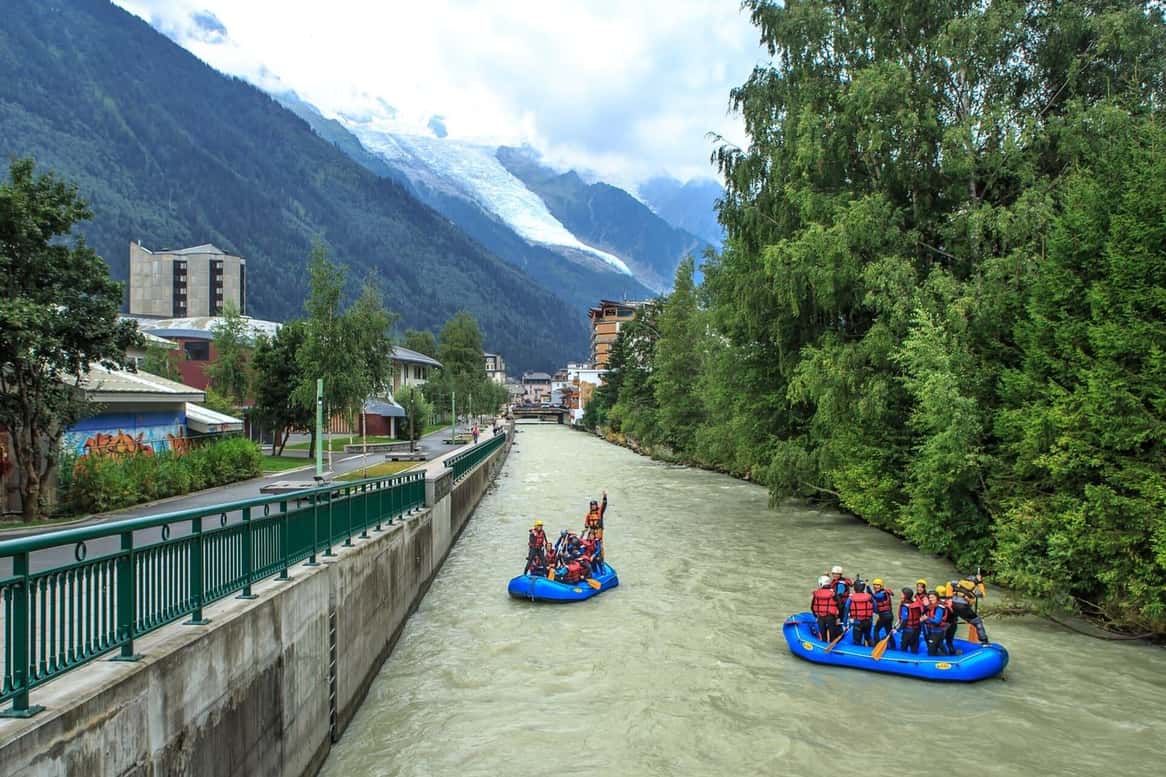 Two rafts on the Arve river in Chamonix, between the embankments of the town and the forested mountainside