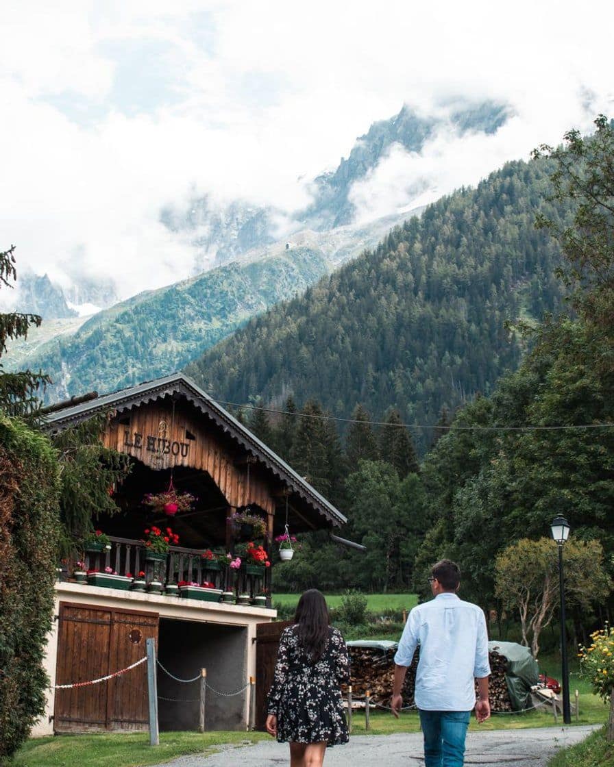 Chalet en bois fleuri dans la vallée de Chamonix en été, promeneurs sur le chemin