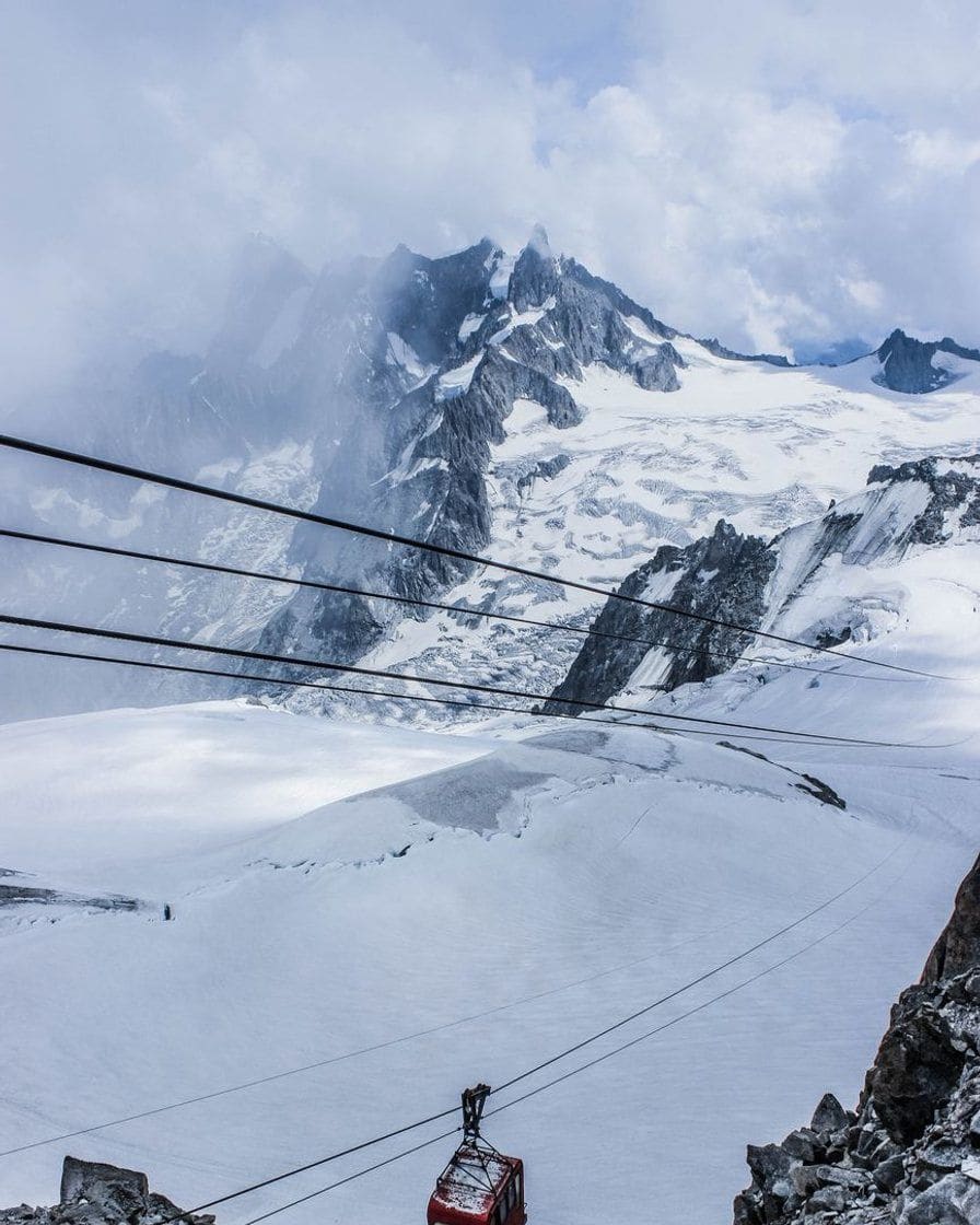 Câbles et cabine rouge d'un téléphérique au-dessus d'un glacier enneigé