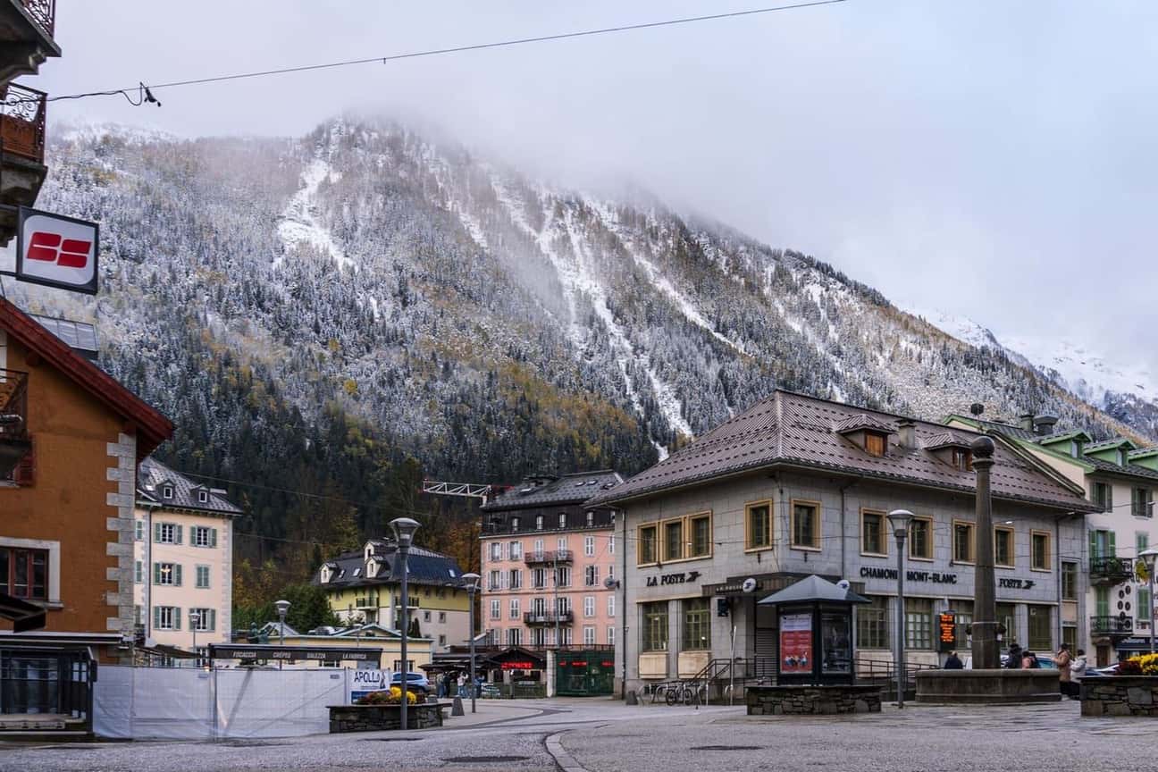 Central Chamonix in early winter, hotels and a historic building at the foot of snow-dusted mountainsides