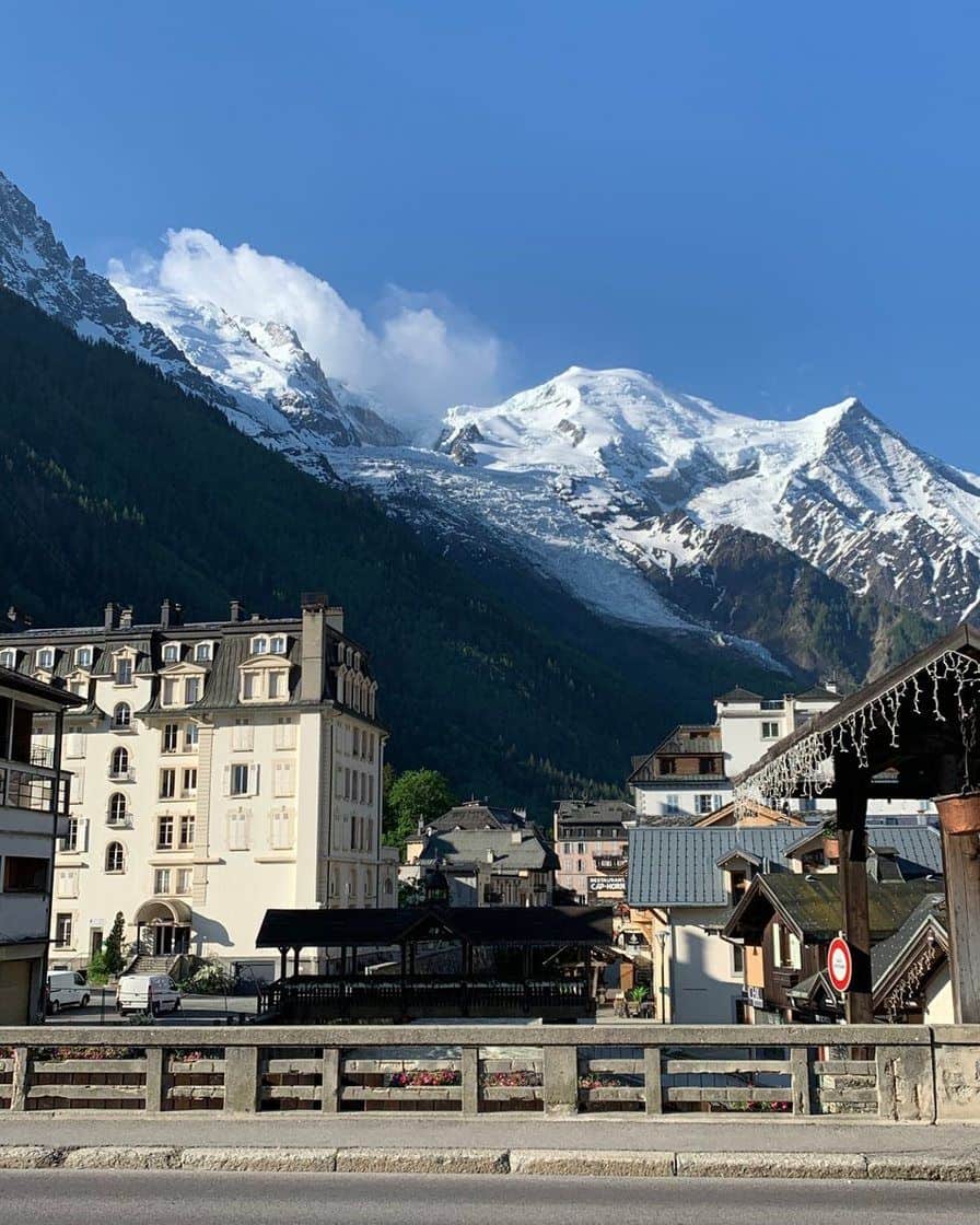 Immeubles Belle Époque du centre de Chamonix au bord de l'Arve, dôme enneigé du Mont-Blanc au-dessus des toits