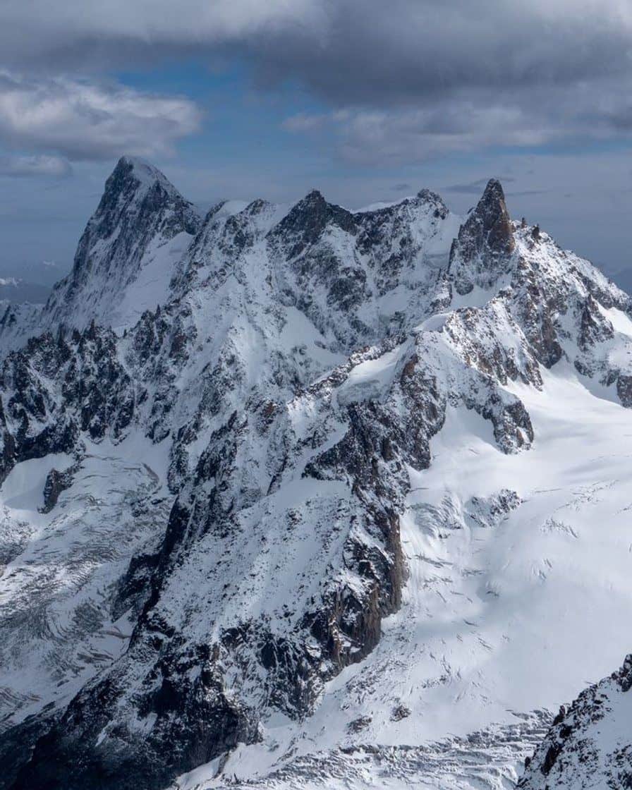 Face rocheuse et enneigée du massif du Mont-Blanc sous un ciel nuageux