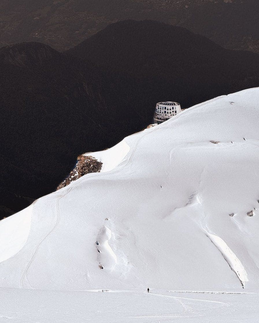 Isolated mountain hut on a snowy slope of the massif